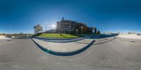 a 360 - view shot of a skateboarder riding on a ramp outside a high rise building