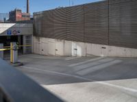 a skateboarder on a ramp looking back at an exit gate in a parking lot