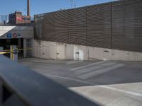 a skateboarder on a ramp looking back at an exit gate in a parking lot