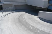 a boy riding a skateboard on the top of a ramp outside of a building