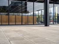 a skateboarder rides his board on the sidewalk outside an office building with windows