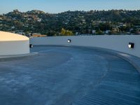 skateboarder is riding along a concrete deck overlooking the city of los angeles below