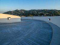 skateboarder is riding along a concrete deck overlooking the city of los angeles below