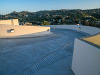 skateboarder is riding along a concrete deck overlooking the city of los angeles below