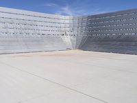 a skateboarder rides down the concrete surface of an empty stadium with seating chairs