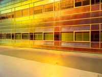 a skateboarder is riding in front of a glass building with lights on it