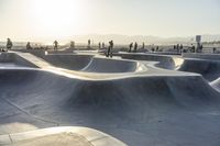 skateboarder riding at a skate park with others nearby, and mountain view in background