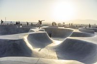 skateboarder riding at a skate park with others nearby, and mountain view in background