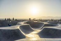 skateboarder riding at a skate park with others nearby, and mountain view in background