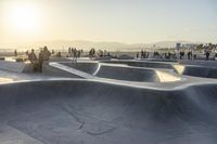 skateboarder riding at a skate park with others nearby, and mountain view in background