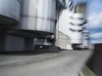 blurred photograph of a skateboarder riding on a city street in front of a building