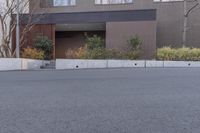 a skate boarder is riding down the middle of an empty street in front of a brown building