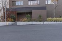 a skate boarder is riding down the middle of an empty street in front of a brown building