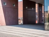 there is a skateboarder riding down a concrete sidewalk in an urban setting on a sunny day