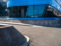 a skateboarder is riding on his board off the edge of a street next to a building