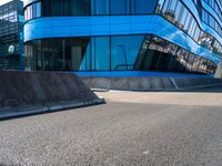 a skateboarder is riding on his board off the edge of a street next to a building