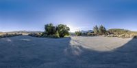 a skateboarder is doing a trick on the cement road in the desert near the mountains