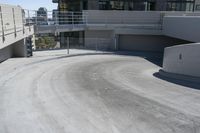 a skateboarder on the road and under some concrete stairs outside of a building