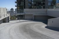 a skateboarder on the road and under some concrete stairs outside of a building