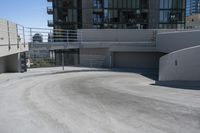 a skateboarder on the road and under some concrete stairs outside of a building