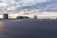 a skateboard in the middle of a road with a city and buildings in the background