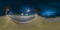 an skateboarder riding down a cement slope at night time with light on the other side