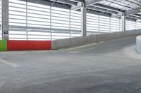 a skateboarder skating on a cement surface under a garage with bright lights above