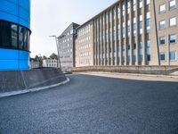 skateboarder skating near the side of a building in an alley with big windows