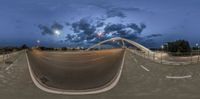 a skateboarder performs a trick in a half pipe in a skate park at night