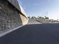 a man on a skateboard does a trick down a road that has some concrete