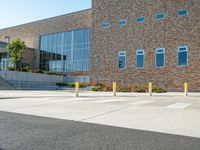 a man riding a skateboard past a big brick building with stairs on it's side