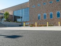 a man riding a skateboard past a big brick building with stairs on it's side