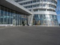 a man on a skateboard near large glass buildings and a building that has windows