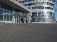 a man on a skateboard near large glass buildings and a building that has windows