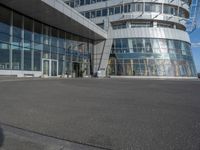 a man on a skateboard near large glass buildings and a building that has windows