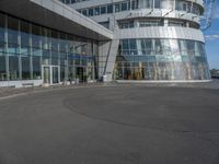 a man on a skateboard near large glass buildings and a building that has windows