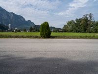 a person riding a skateboard on the pavement and looking up at a mountain range