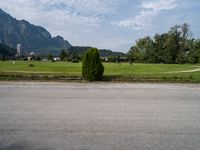 a person riding a skateboard on the pavement and looking up at a mountain range