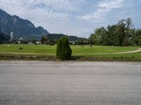 a person riding a skateboard on the pavement and looking up at a mountain range