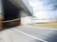 a skateboarder in motion in front of a building with a sky background and a blurred backdrop