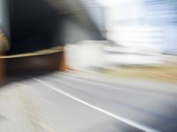 a skateboarder in motion in front of a building with a sky background and a blurred backdrop