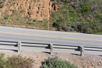 a person on a skateboard on the side of a winding road with a ramp