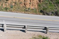 a person on a skateboard on the side of a winding road with a ramp