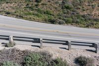 a person on a skateboard on the side of a winding road with a ramp