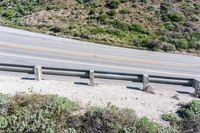 a person on a skateboard on the side of a winding road with a ramp