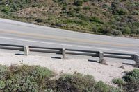 a person on a skateboard on the side of a winding road with a ramp