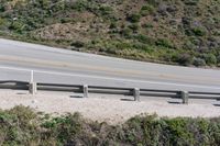 a person on a skateboard on the side of a winding road with a ramp