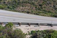 a person on a skateboard on the side of a winding road with a ramp