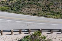 a person on a skateboard on the side of a winding road with a ramp