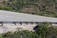 a person on a skateboard on the side of a winding road with a ramp